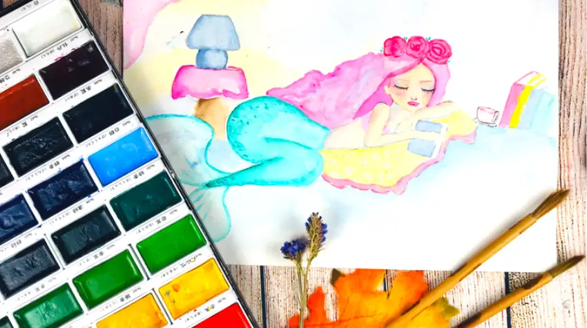 watercolor mermaid painting next to watercolor set and paintbrushes